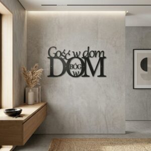 Czarny, wycinany laserowo napis metalowy Gość w dom Bóg w dom, zawieszony na jasnej ścianie w gościnnym, stylowo urządzonym salonie lub wiatrołapie.