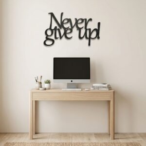 Czarny, wycinany laserowo napis metalowy Never give up, zawieszony na jasnej ścianie w nowoczesnym, dobrze oświetlonym pomieszczeniu do pracy.