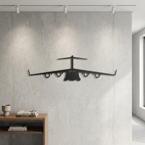 Czarny metalowy samolot wojskowy Boeing C-17 Globemaster zawieszony na betonowej ścianie z reflektorami pod sufitem