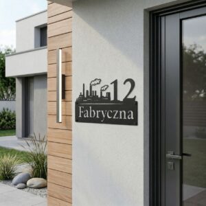 Metalowa tabliczka adresowa na dom z industrialnym motywem fabryki, zamontowana na nowoczesnej elewacji budynku