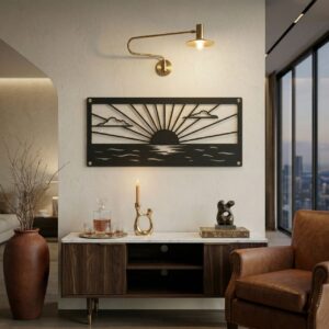 Czarny, wycinany laserowo metalowy obraz przedstawiający zachód słońca nad wodą, zawieszony na jasnej ścianie nad drewnianą komodą obok skórzanego fotela.