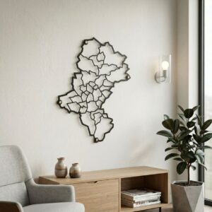Czarna ażurowa mapa województwa śląskiego z podziałem na powiaty zawieszona nad drewnianą szafką w jasnym salonie.