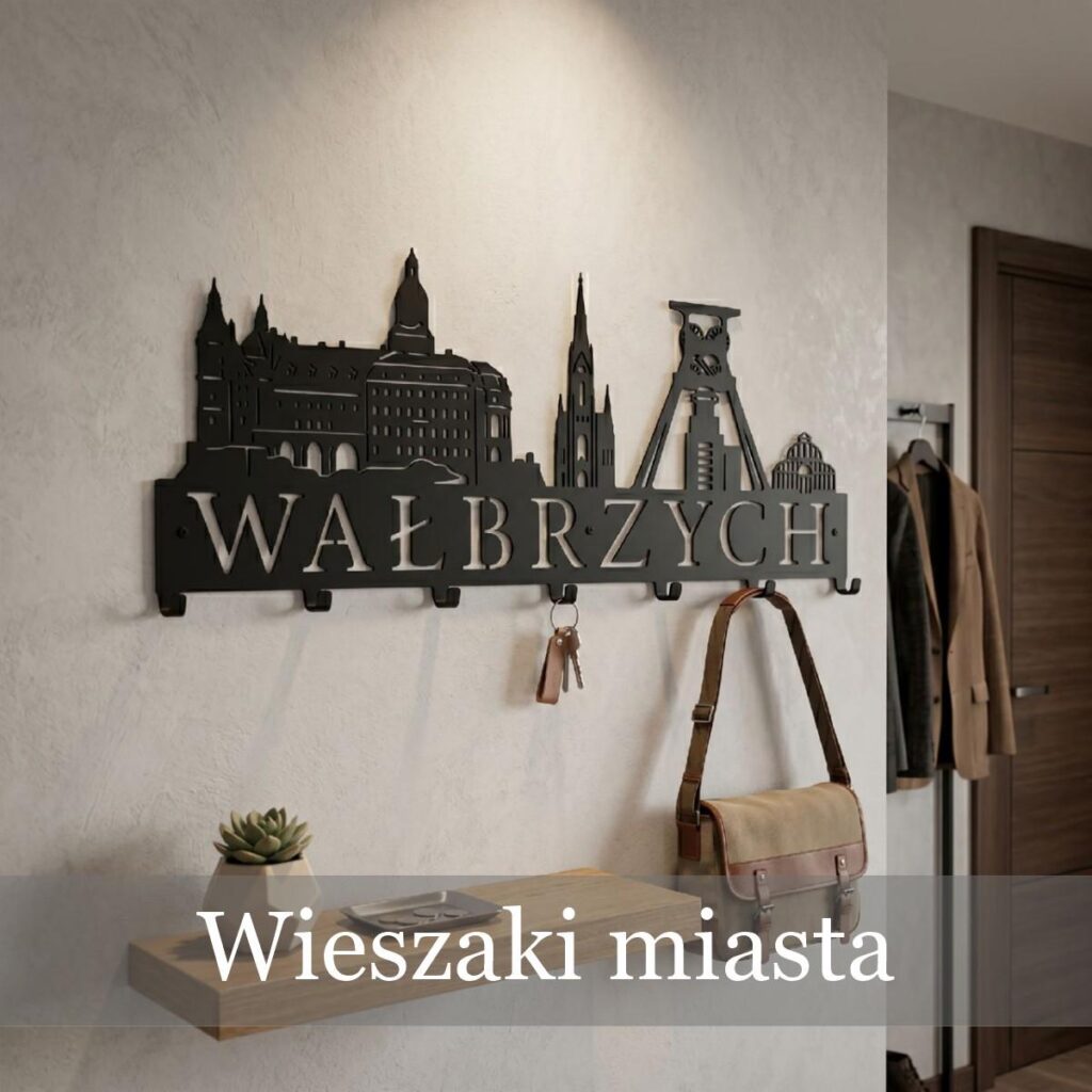 Metalowy wieszak ścienny przedstawiający sylwetkę i zabytki Wałbrzycha ze stali, zamontowany nad półką na klucze.
