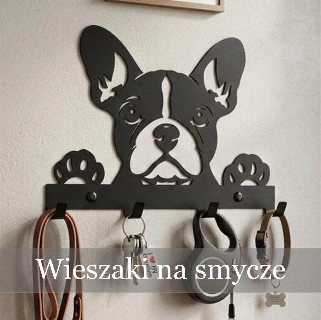 Metalowy wieszak na klucze i smycze z wyciętym motywem głowy buldoga francuskiego, z zawieszonymi kluczami i smyczą automatyczną.
